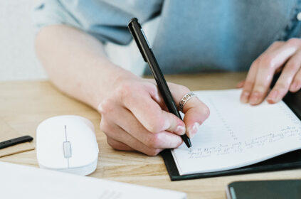 Person at their desk writing in a journal