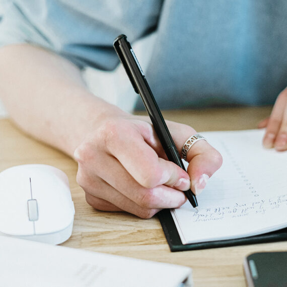 Person at their desk writing in a journal